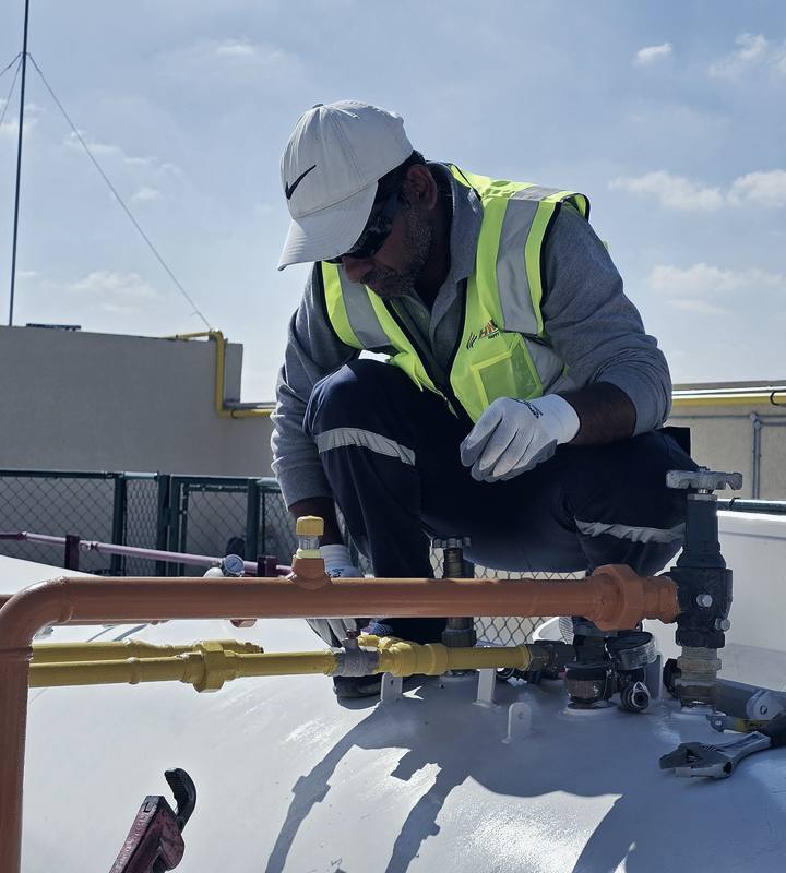Happy Way Gas technician with gloves and hi-vis performing LPG safety inspection